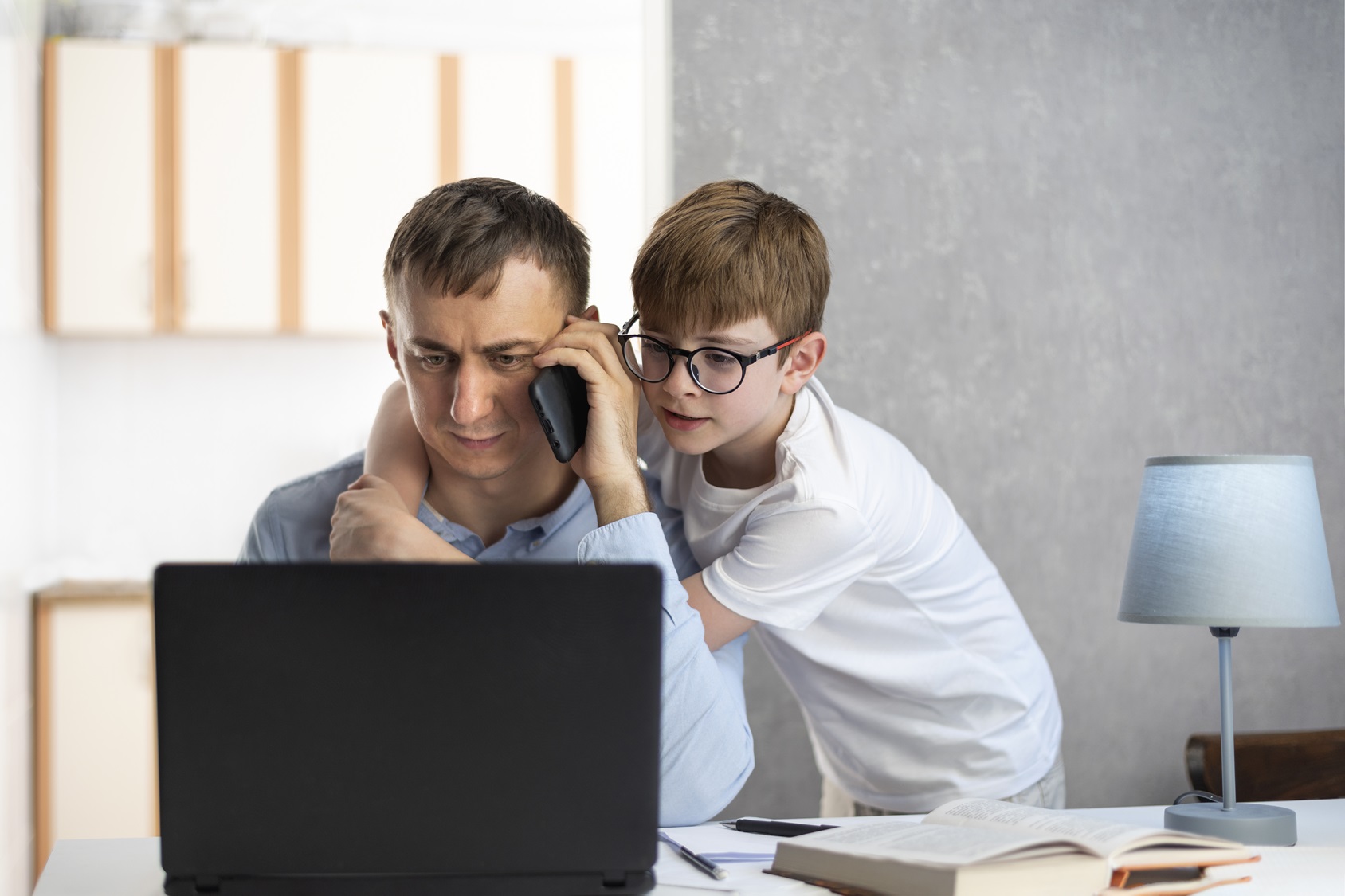 son-distracts-his-father-from-work-looking-into-his-laptop-man-freelancer-talks-on-the-phone-and-works-at-the-computer-at-home-with-child